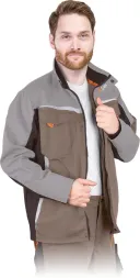 Bluza ochronna w kolorach szarym i brązowym, ma wielokolorowe wstawki i kilka kieszeni. Zapinana na zamek, z kołnierzem stójkowym i długimi rękawami.