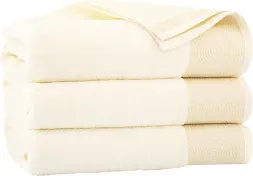 Ręcznik Elipse w kolorze białym, wykonany z tkaniny o strukturze frotte, zdobiony delikatnym reliefowym wzorem. Produkt jest składany w stos kilku sztuk.