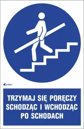 Znak informujący o obowiązku trzymania się poręczy podczas wchodzenia i schodzenia po schodach, z napisem „TRZYMAJ SIĘ PORĘCZY SCHODZĄC I WCHODZĄC PO SCHODACH”.