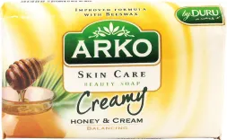 Mydło Arko Creamy o zapachu miodu i kremu, wzbogacone formułą pielęgnacyjną. Opakowanie kremowo-zielone z grafiką plasterka miodu.