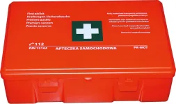 Czerwona apteczka samochodowa z białym krzyżem i napisami informacyjnymi. Na pokrywie widnieje symbol 