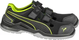 Czarne buty bezpieczne z niską cholewką, mają rzepy i fluorescencyjne zielone akcenty. Znak z motywem kociej łapy widoczny na boku.
